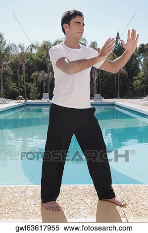 Stock Photography - Man exercising at the poolside. Fotosearch