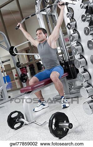 Man exercising in a gym View Large Photo Image Stock Image - Man exercising in a gym. Fotosearch