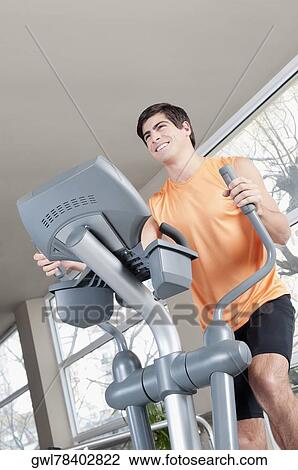 Man exercising on a stepping machine in a gym View Large Photo Image Stock Image - Man exercising on a stepping machine in a gym. Fotosearch