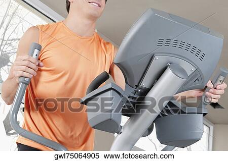 Man exercising on a stepping machine in a gym View Large Photo Image Stock Photography - Man exercising on a stepping machine in a gym. Fotosearch