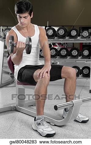 Man exercising with dumbbells in a gym View Large Photo Image Stock Image - Man exercising with dumbbells in a gym. Fotosearch
