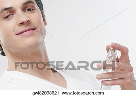 Man holding a perfume bottle View Large Photo Image Stock Image - Man holding a perfume bottle. Fotosearch