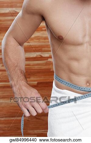 Man measuring his waist with a tape measure View Large Photo Image Stock Image - Man measuring his waist with a tape measure. Fotosearch