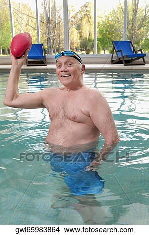 Man playing with a rugby ball in a swimming pool View Large Photo Image Picture - Man playing with a rugby ball in a swimming pool. Fotosearch