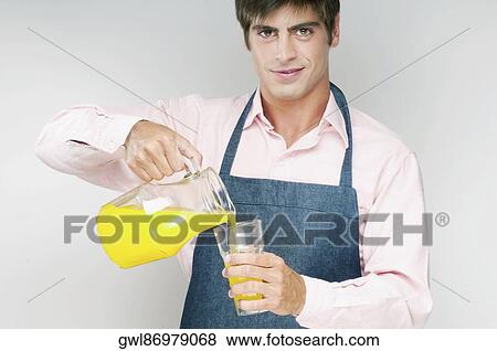 Man pouring orange juice in a glass View Large Photo Image Stock Photo - Man pouring orange juice in a glass. Fotosearch
