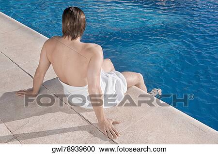 Stock Image - Man resting at the poolside. Fotosearch