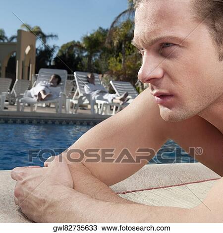 Man resting at the poolside View Large Photo Image Stock Image - Man resting at the poolside. Fotosearch