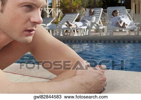 Man resting at the poolside View Large Photo Image Stock Image - Man resting at the poolside. Fotosearch