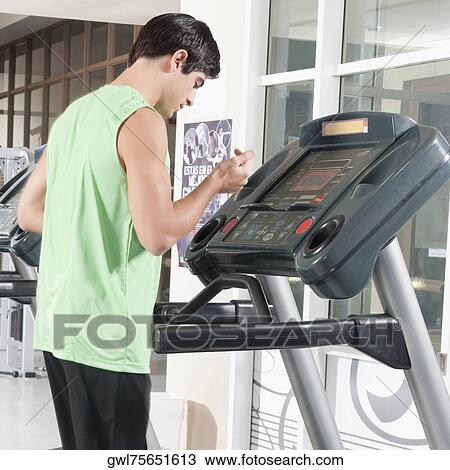 Stock Image - Man standing on a treadmill. Fotosearch