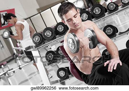 Men lifting weights at gym View Large Photo Image Stock Photograph - Men lifting weights at gym. Fotosearch