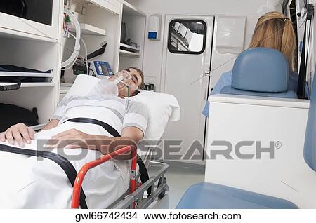 Patient with a female nurse in an ambulance View Large Photo Image Picture - Patient with a female nurse in an ambulance. Fotosearch