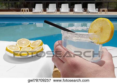 Person's hand holding a glass of lemonade View Large Photo Image Stock Photo - Person's hand holding a glass of lemonade. Fotosearch