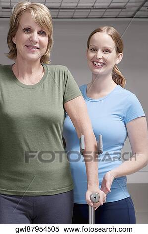 Physiotherapist assisting a patient in walking with crutches View Large Photo Image Stock Photography - Physiotherapist assisting a patient in walking with crutches. Fotosearch
