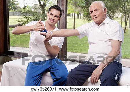 Physiotherapist examining a man's hand View Large Photo Image Stock Image - Physiotherapist examining a man's hand. Fotosearch