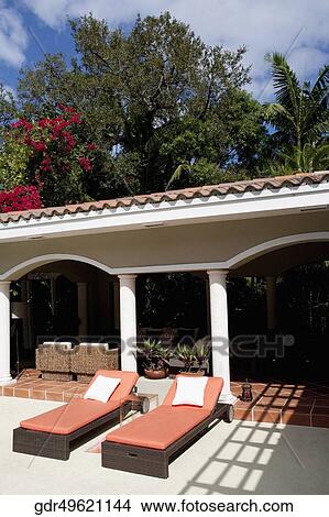 Picture - Porch of a house with lounge chairs. Fotosearch