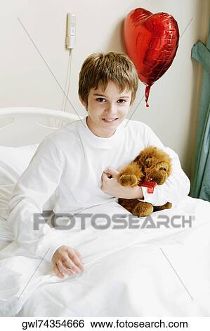 Stock Photograph - Portrait of a boy sitting on a hospital bed. Fotosearch