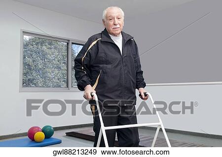Stock Photo - Portrait of a disabled man walking with a walker. Fotosearch