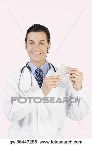 Portrait of a doctor holding a blister pack capsules View Large Photo Image Stock Photography - Portrait of a doctor holding a blister pack capsules. Fotosearch