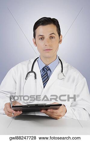 Stock Photo - Portrait of a doctor holding a clipboard. Fotosearch