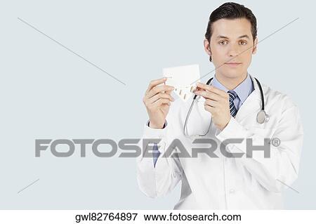 Portrait of a doctor holding a medicine pack View Large Photo Image Stock Photo - Portrait of a doctor holding a medicine pack. Fotosearch