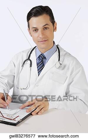 Portrait of a doctor writing on a clipboard View Large Photo Image Stock Photo - Portrait of a doctor writing on a clipboard. Fotosearch