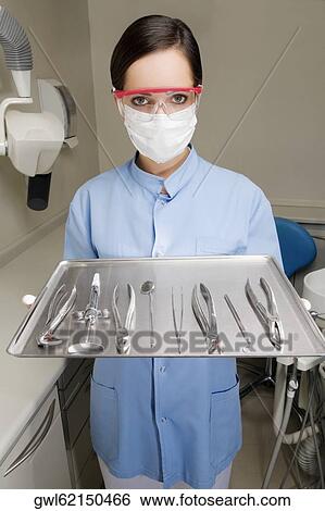 Portrait of a female dentist holding a tray of dental equipments View Large Photo Image Stock Photograph - Portrait of a female dentist holding a tray of dental equipments. Fotosearch