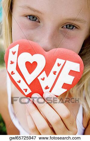 Portrait of a girl holding a valentine card View Large Photo Image Stock Photo - Portrait of a girl holding a valentine card. Fotosearch