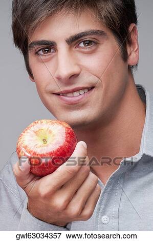 Portrait of a man eating an apple View Large Photo Image Stock Photo - Portrait of a man eating an apple. Fotosearch