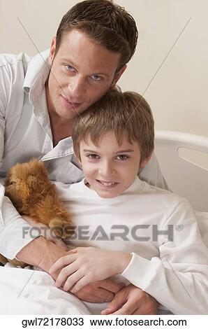 Portrait of a man hugging his son on a hospital bed View Large Photo Image Stock Image - Portrait of a man hugging his son on a hospital bed. Fotosearch