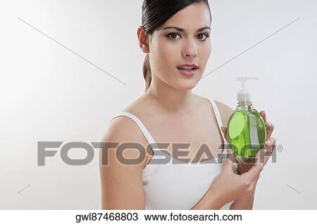 Portrait of a woman holding a bottle of liquid soap View Large Photo Image Stock Image - Portrait of a woman holding a bottle of liquid soap . Fotosearch