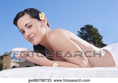 Portrait of a woman holding a bowl on a massage table View Large Photo Image Stock Image - Portrait of a woman holding a bowl on a massage table. Fotosearch
