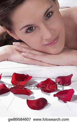 Portrait of a woman lying on a massage table with rose petals View Large Photo Image Stock Photo - Portrait of a woman lying on a massage table with rose petals. Fotosearch