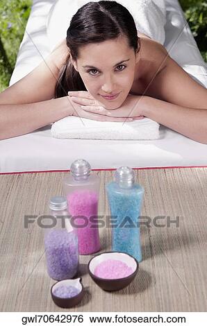 Portrait of a woman lying on a massage table with bath salt View Large Photo Image Stock Photograph - Portrait of a woman lying on a massage table with bath salt. Fotosearch
