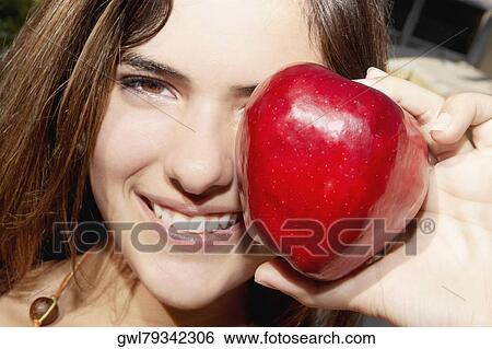 Portrait of a woman showing an apple View Large Photo Image Stock Photograph - Portrait of a woman showing an apple. Fotosearch