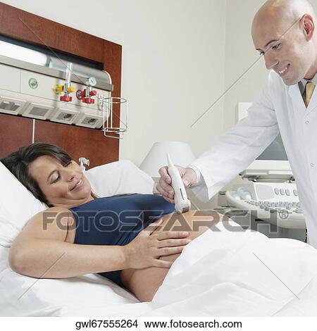 Picture - Pregnant woman going through an ultrasound scan. Fotosearch