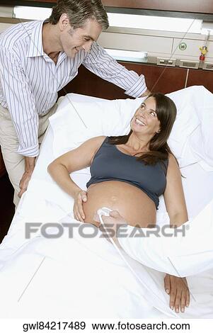 Pregnant woman going through an ultrasound scan View Large Photo Image Stock Photo - Pregnant woman going through an ultrasound scan. Fotosearch