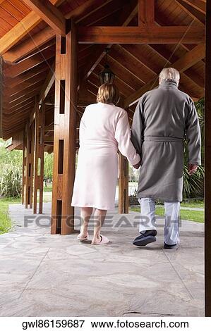 Stock Photo - Rear view of a couple walking in a rehabilitation centre. Fotosearch