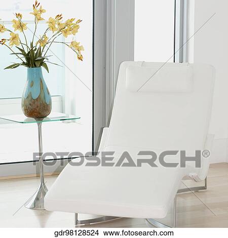 Reclining chair with a flower vase in a room View Large Photo Image Picture - Reclining chair with a flower vase in a room. Fotosearch