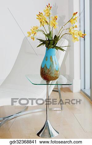Reclining chair with a flower vase in a room View Large Photo Image Stock Image - Reclining chair with a flower vase in a room. Fotosearch