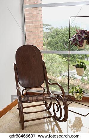 Rocking chair near a window View Large Photo Image Stock Photo - Rocking chair near a window. Fotosearch