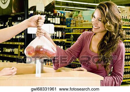 Sales clerk giving a plastic bag of apples to a woman View Large Photo Image Stock Image - Sales clerk giving a plastic bag of apples to a woman. Fotosearch