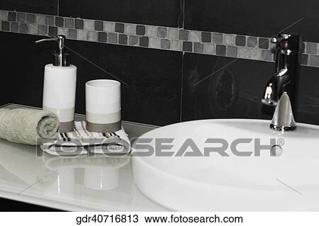 Soap dispenser and a towel on a bathroom sink View Large Photo Image Stock Image - Soap dispenser and a towel on a bathroom sink. Fotosearch