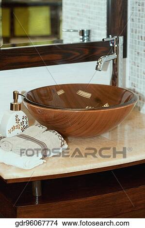 Picture - Soap dispenser and towels on a bathroom sink. Fotosearch