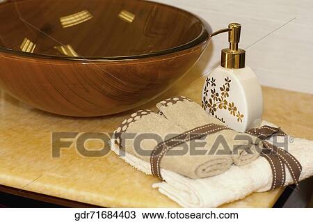 Soap dispenser and towels on a bathroom sink View Large Photo Image Stock Image - Soap dispenser and towels on a bathroom sink. Fotosearch