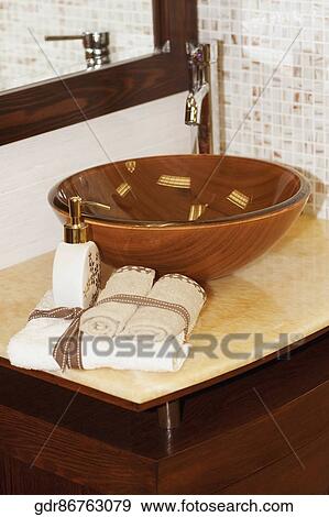 Soap dispenser and towels on a bathroom sink View Large Photo Image Stock Photo - Soap dispenser and towels on a bathroom sink. Fotosearch