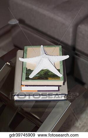 Stock Photo - Starfish on a stack of books on a table. Fotosearch