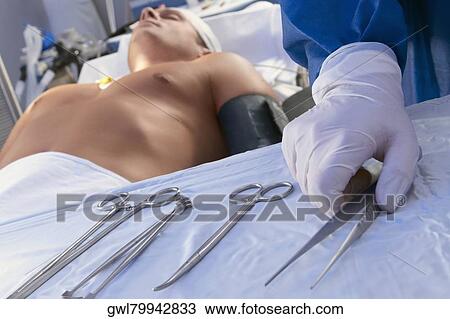 Surgeon holding surgical scissors in an operating room View Large Photo Image Stock Image - Surgeon holding surgical scissors in an operating room. Fotosearch