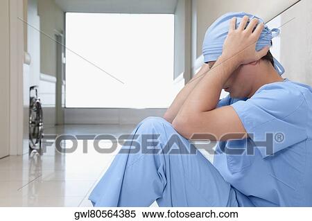 Surgeon sitting on the floor looking depressed View Large Photo Image Stock Photography - Surgeon sitting on the floor looking depressed. Fotosearch