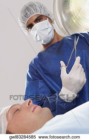 Surgeon with a patient in an operating room View Large Photo Image Stock Photography - Surgeon with a patient in an operating room. Fotosearch