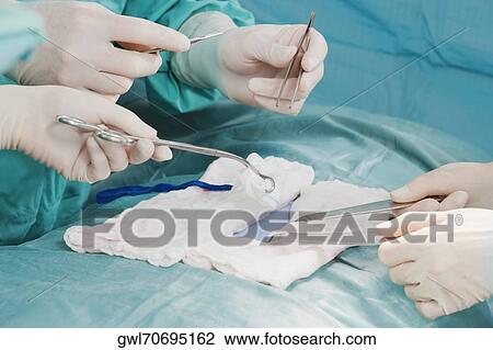 Surgeons performing a surgery in an operating room View Large Photo Image Stock Image - Surgeons performing a surgery in an operating room. Fotosearch